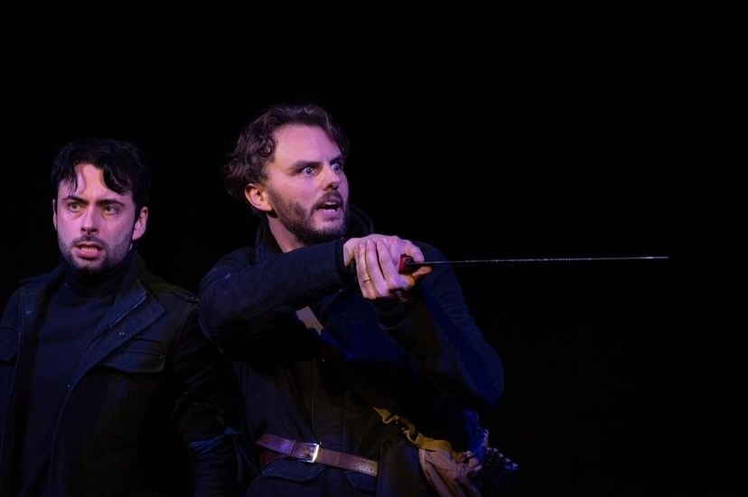 performance image of Elysium Theatre Production Macbeth, an actor holds a sword up in an action shot. 